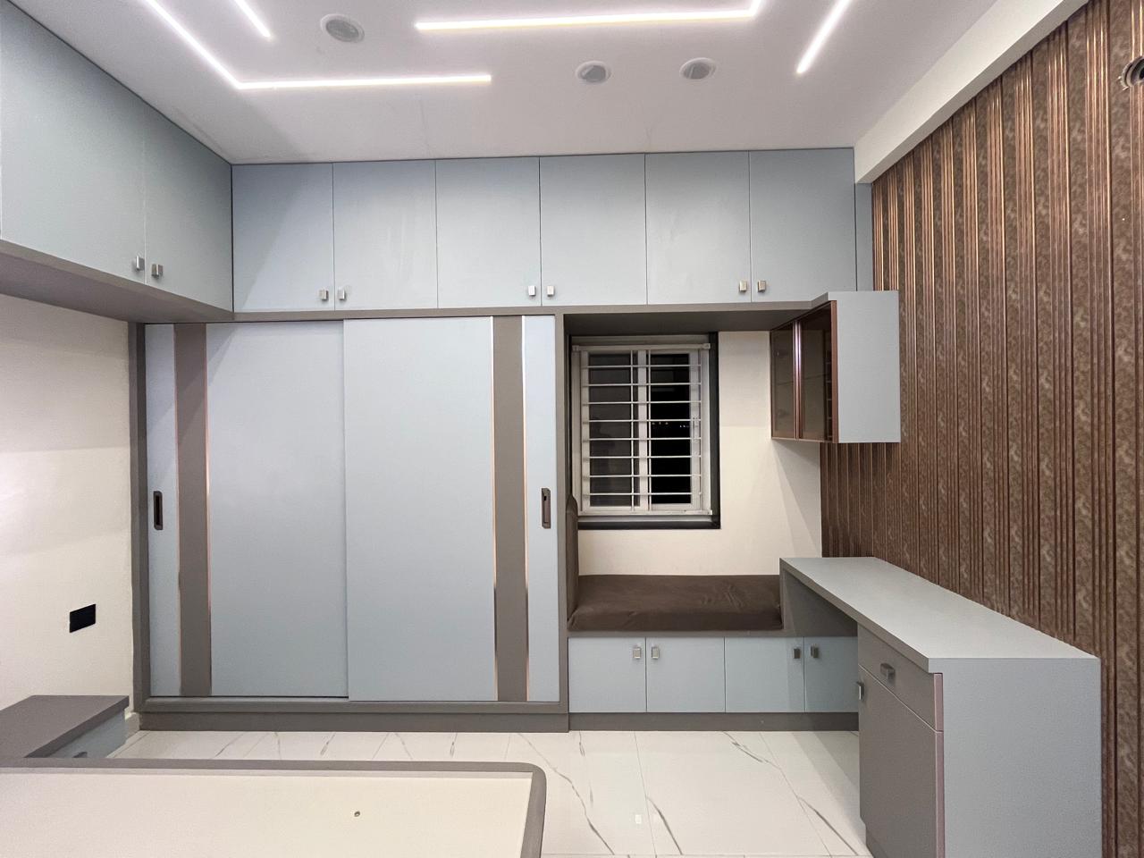 Powder blue sliding wardrobe with window seat and fluted feature wall