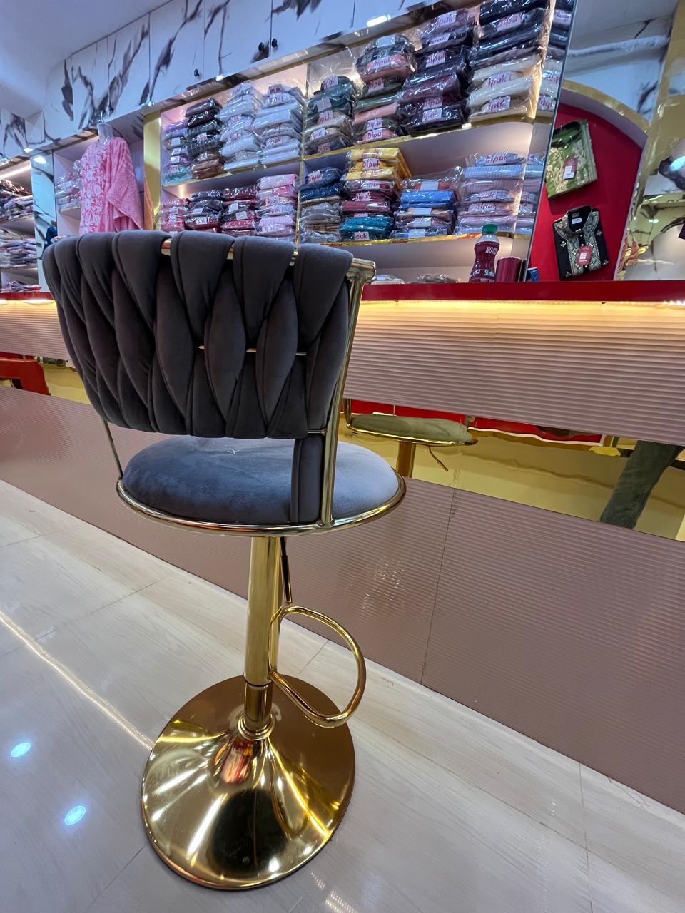 Gold-base velvet bar stool at retail counter