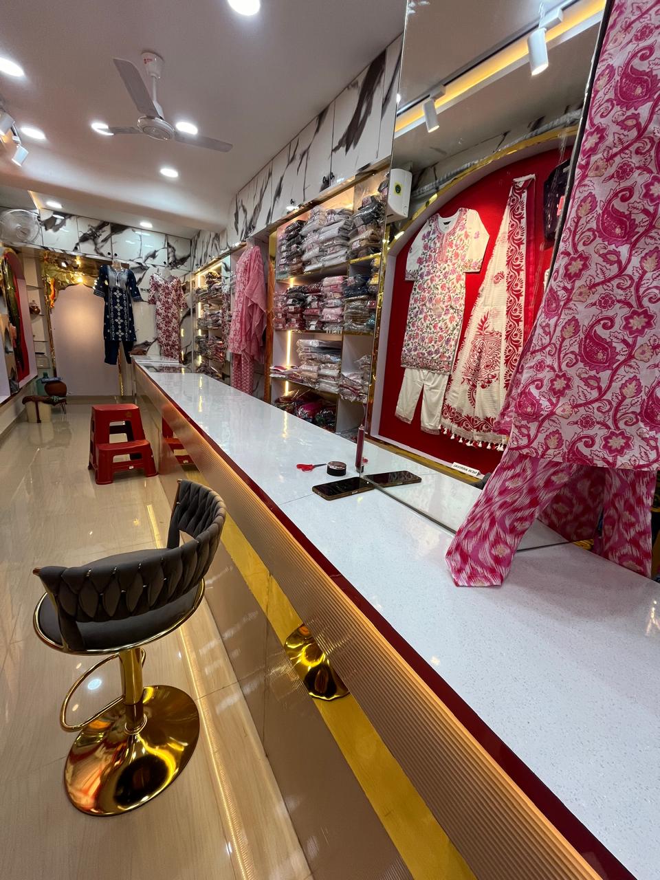 Showroom counter with bar stool and apparel display